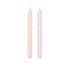 Two tall, slender taper candles in a pale blush pink color, standing upright side-by-side on a solid white background.