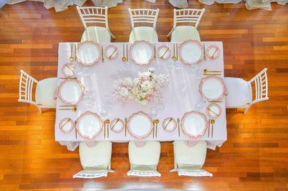 Pink Elegance party package: A beautifully set table with plates, flowers, and elegant tableware for a memorable dinner party.