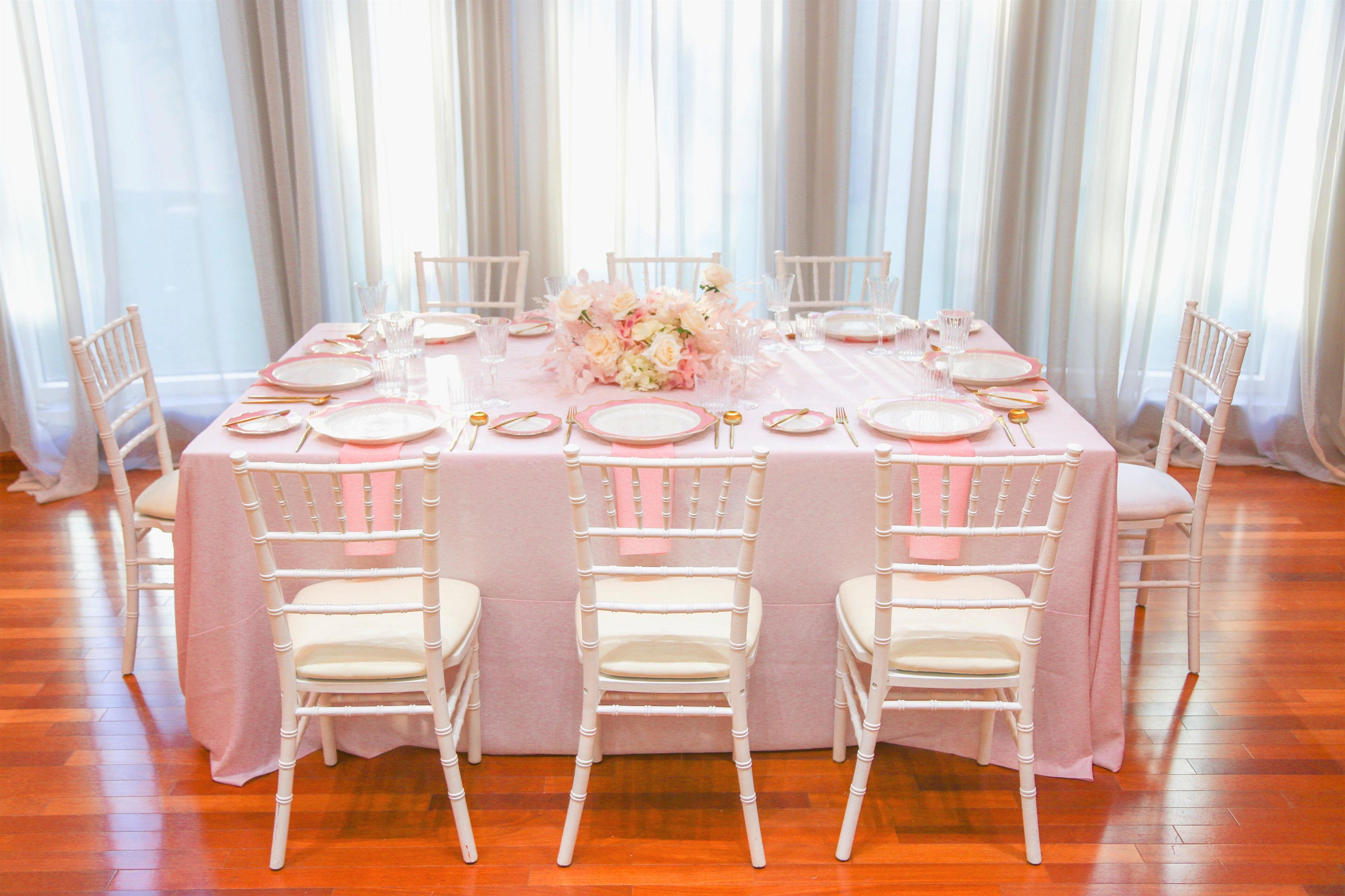 Pink Elegance table set for a party of 8 with chairs, tableware, and centrepieces. Rent everything you need for a remarkable event from Party Social.
