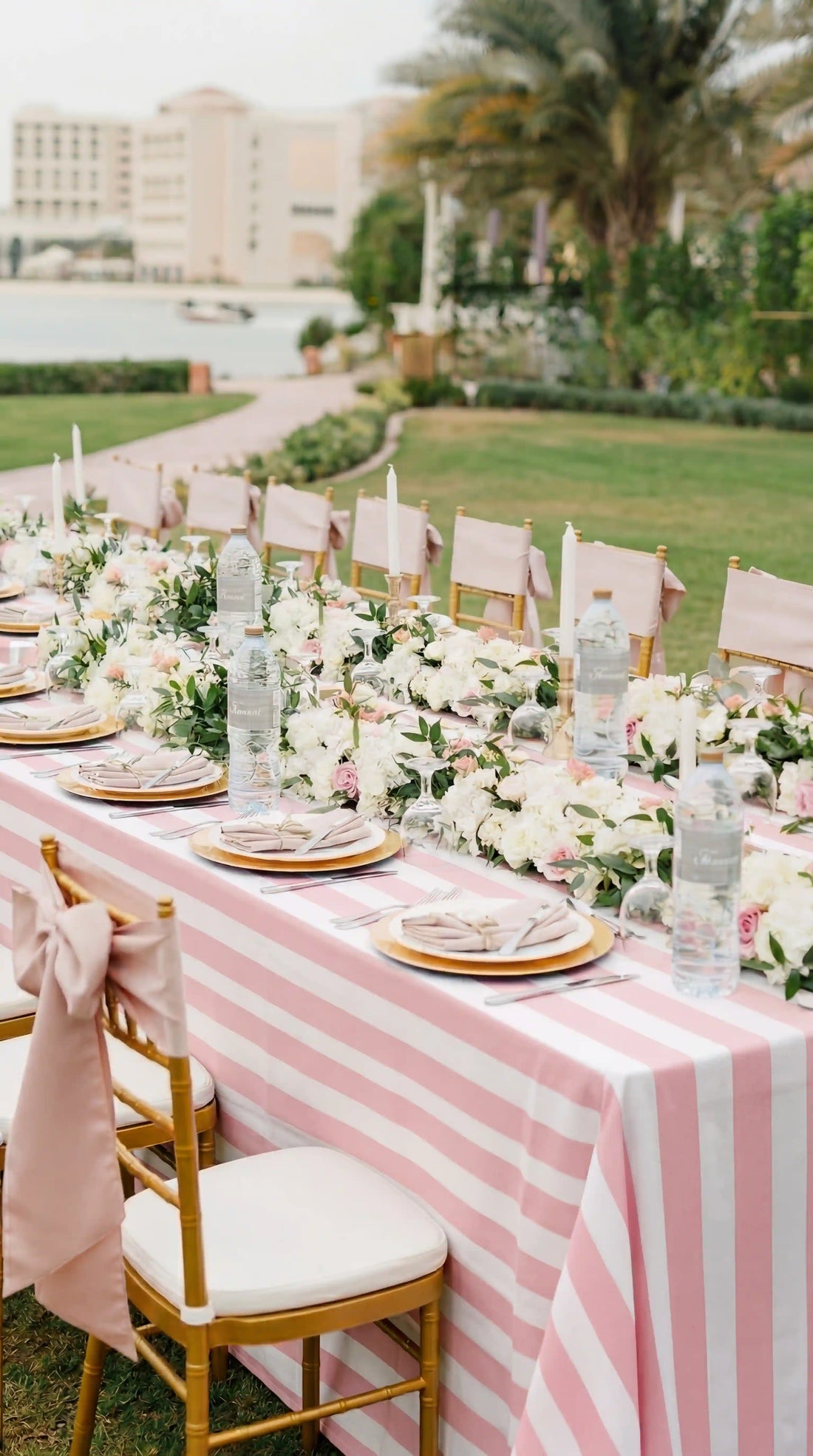 Pink Stripe Linen Tablecloth elegantly drapes a banquet table with gold chargers, pink sashes, and floral garland, set for a garden party.