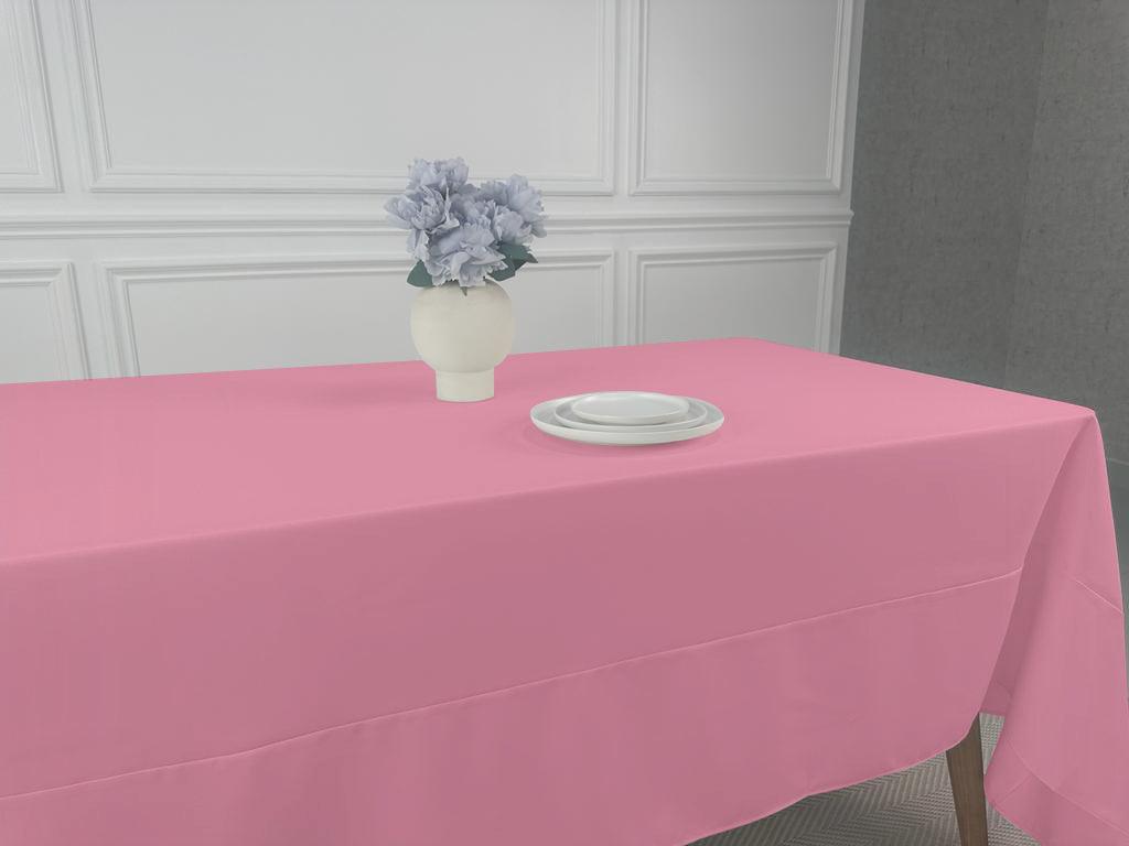 A pink tablecloth with a white plate and a vase of flowers, perfect for any table setting.