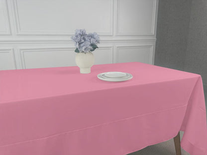 A pink tablecloth with a white plate and a vase of flowers, perfect for any table setting.