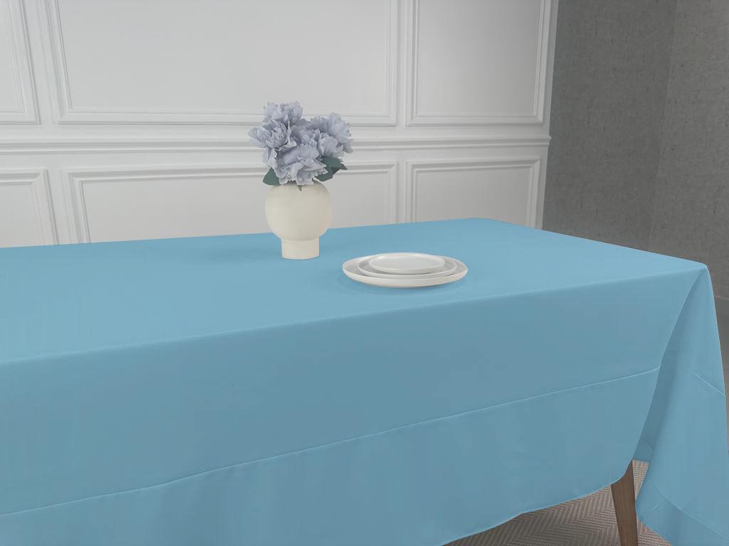 A Polycotton Tablecloth with a vase of flowers and white plates on it.