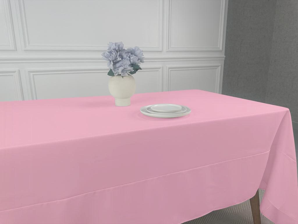 A pink Polycotton Tablecloth with a vase of flowers and plates on it, perfect for any event or occasion.