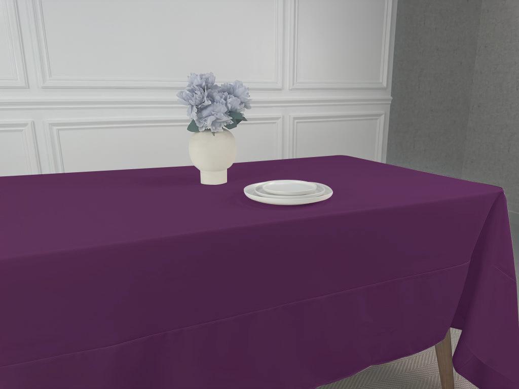 A Polycotton Tablecloth with a white plate and a vase of flowers, perfect for any table setting.
