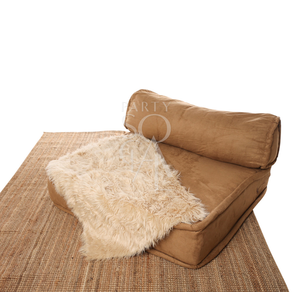 SHEEPSKIN RECTANGULAR draped over a brown couch, ideal for event decor or prop use.