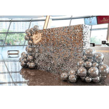 Silver Sequin Wall Balloon Backdrop with LED Neon Sign, featuring shiny silver balls, ideal for events like weddings and parties.