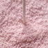A close-up of light pink sugar crystals or sprinkles with a single white stick standing vertically in the center.